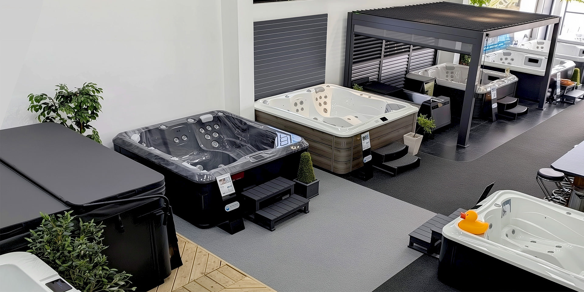 A riptide showroom display featuring multiple hot tubs and a covered patio setup. 