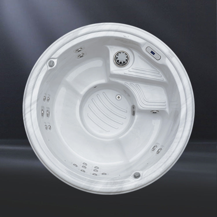 A round, white hot tub with multiple jets